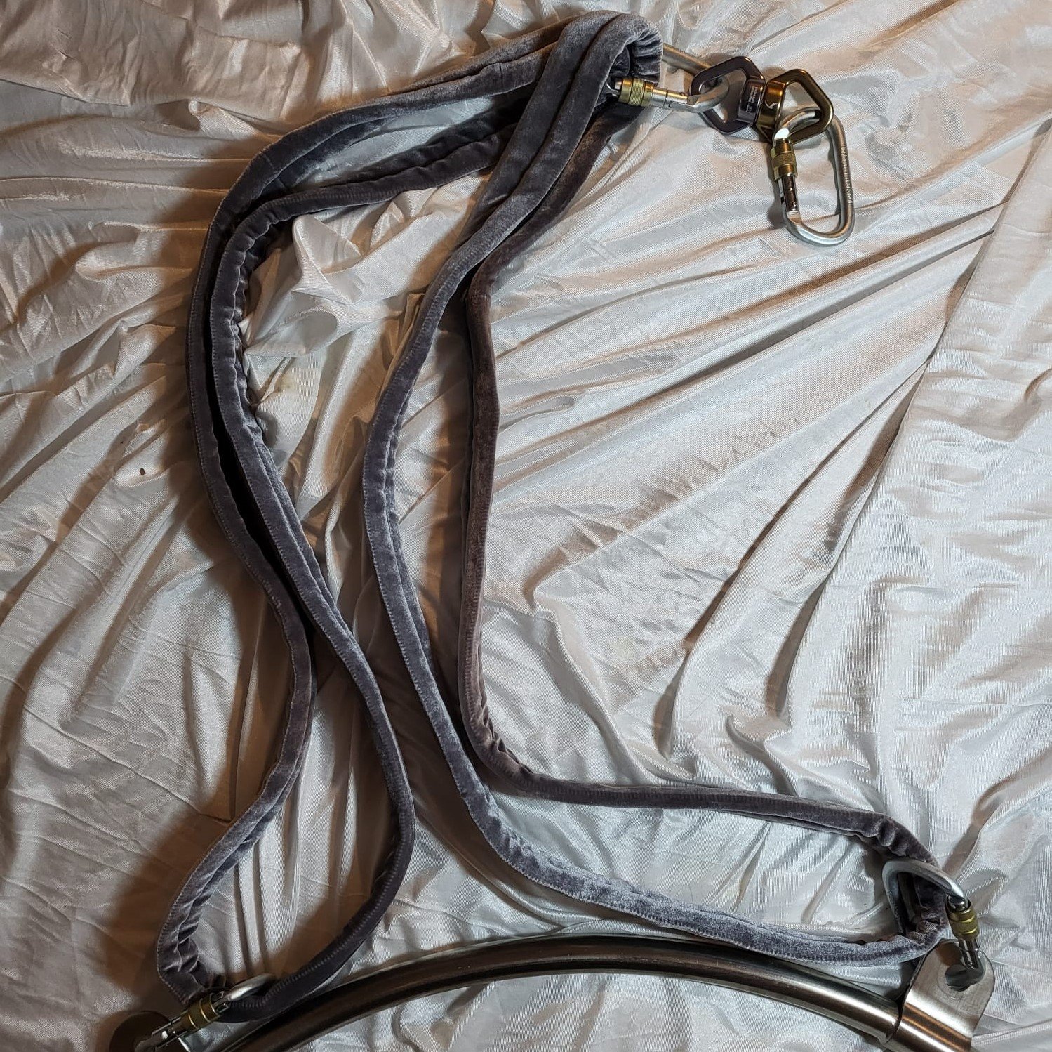 Ein Luftring mit zwei Aufhängungspunkten und Zubehör aus Karabinern, Schlingen und Wirbel, ideal für Luftakrobatik Training zu Hause oder im Studio. Ein Luftring mit zwei Aufhängungspunkten und Zubehör aus Karabinern, Schlingen und Wirbel, ideal für Luftakrobatik Training zu Hause oder im Studio.